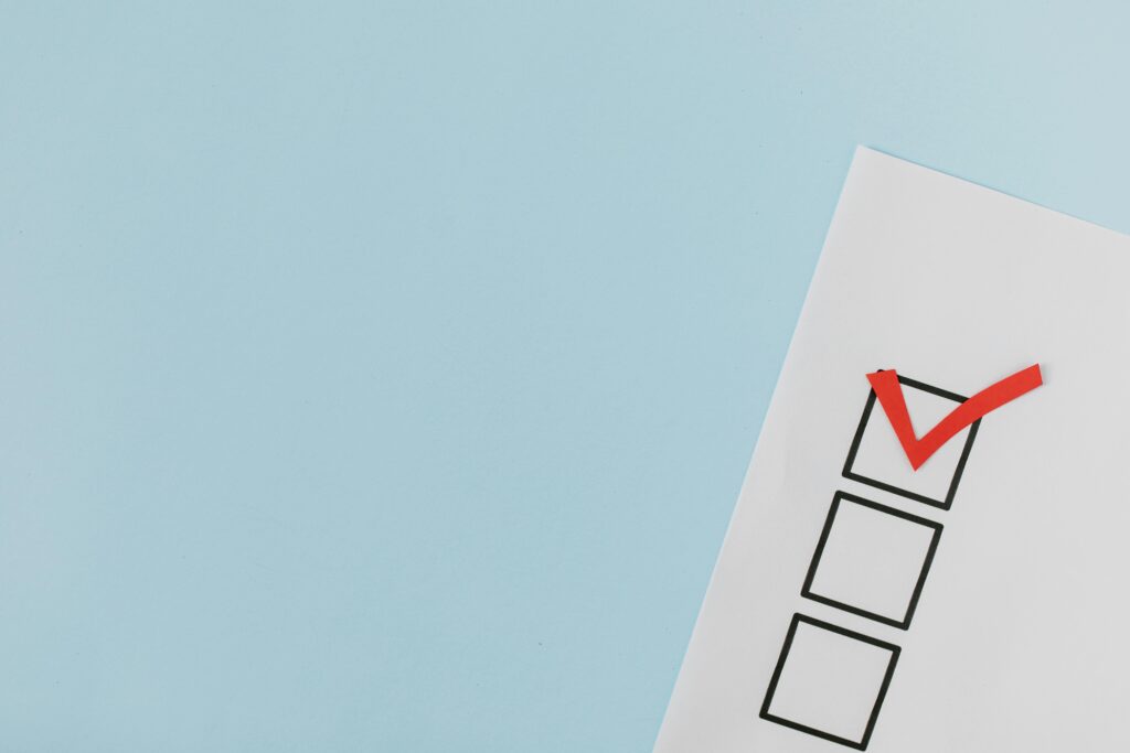 A checklist with a red checkmark symbolizing a completed task on a pastel blue background.